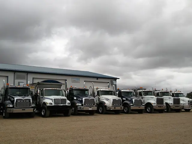 Row of detailed white fleet trucks in front of a shop
