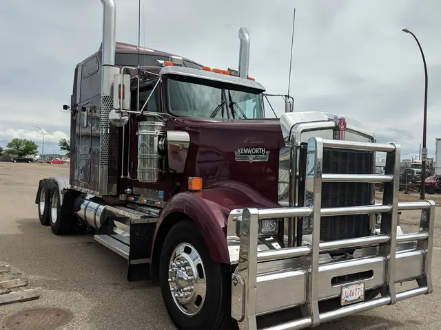 Maroon Kenworth highway tractor with polished bumper and chrome stacks