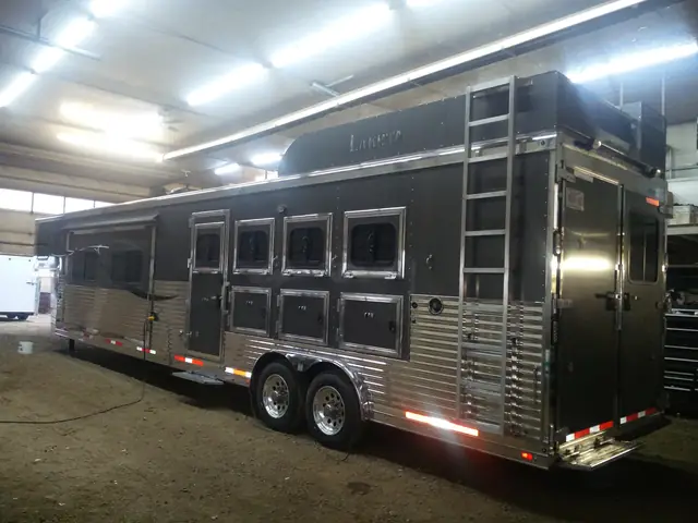 Polished aluminum livestock trailer inside a shop
